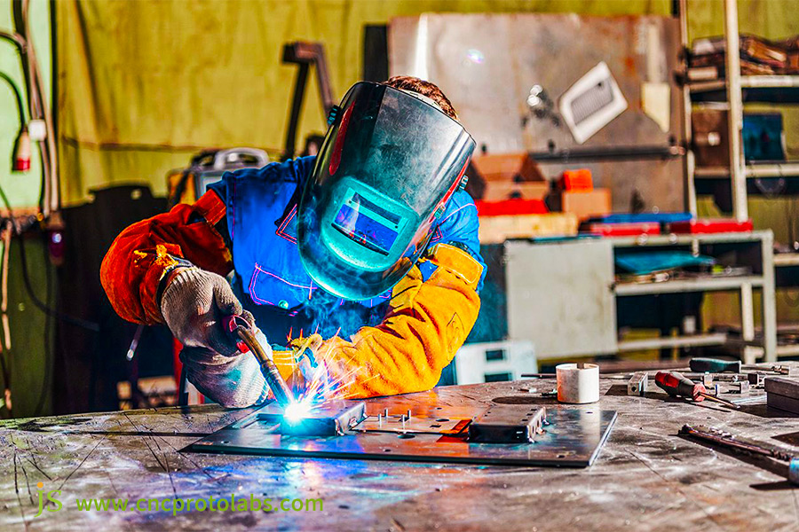 Welder at work using MIG welding equipment